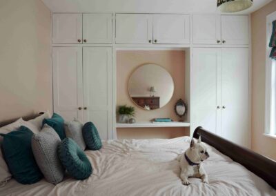 A French bulldog on the bed in a guest bedroom at the Country Dog Hotel
